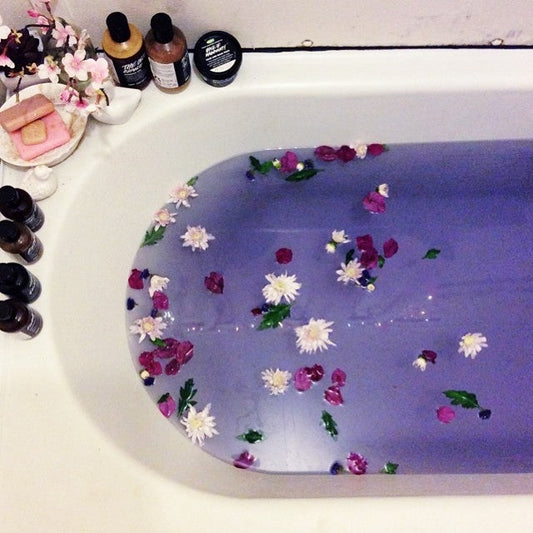 Lavender bath salts in a glass jar beside a warm bath