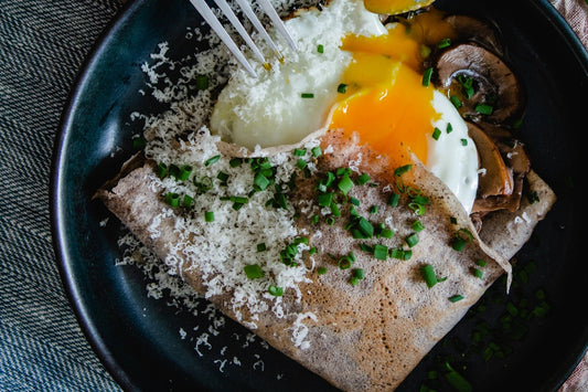 Savoury buckwheat crepes and mushroom risotto on a wooden table
